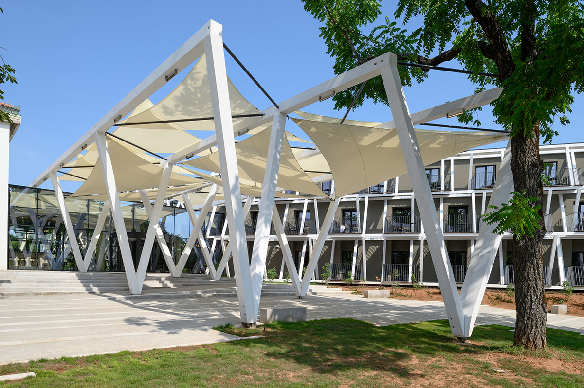 Enota designs hotel with aggressive façade made of white fences in Slovenia