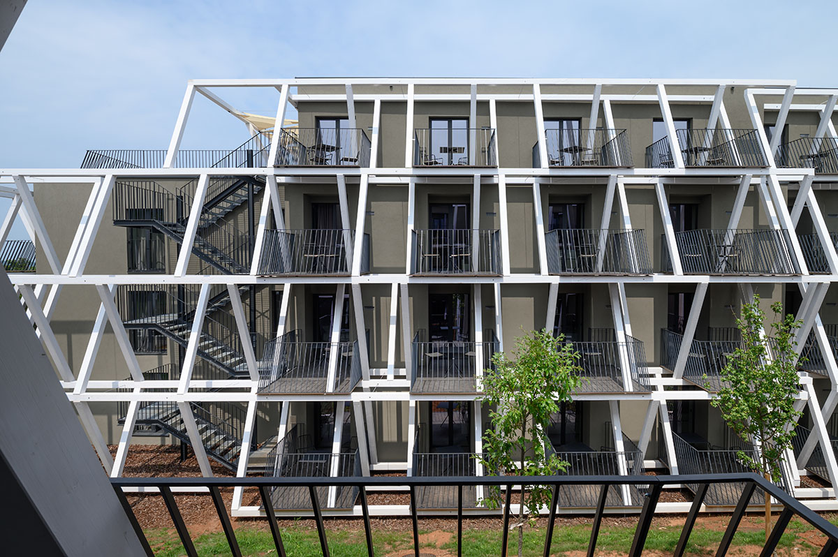 Enota designs hotel with aggressive façade made of white fences in Slovenia