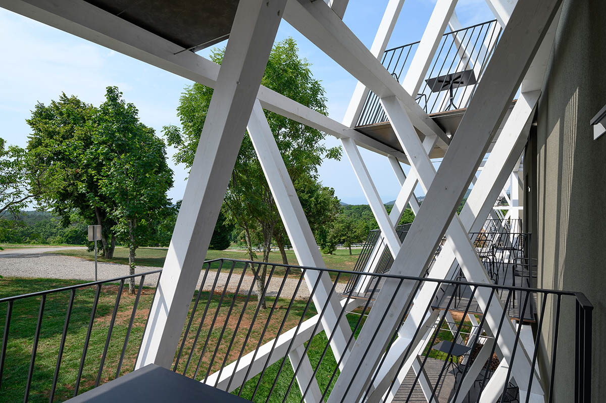 Enota designs hotel with aggressive façade made of white fences in Slovenia