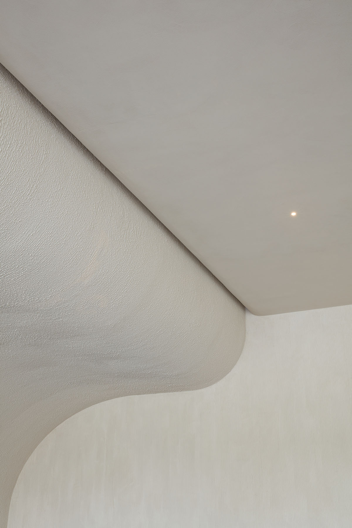 Интерьер кофейни от VSHD с большими каменными блоками неправильной формы и изогнутым потолком в Дубае.