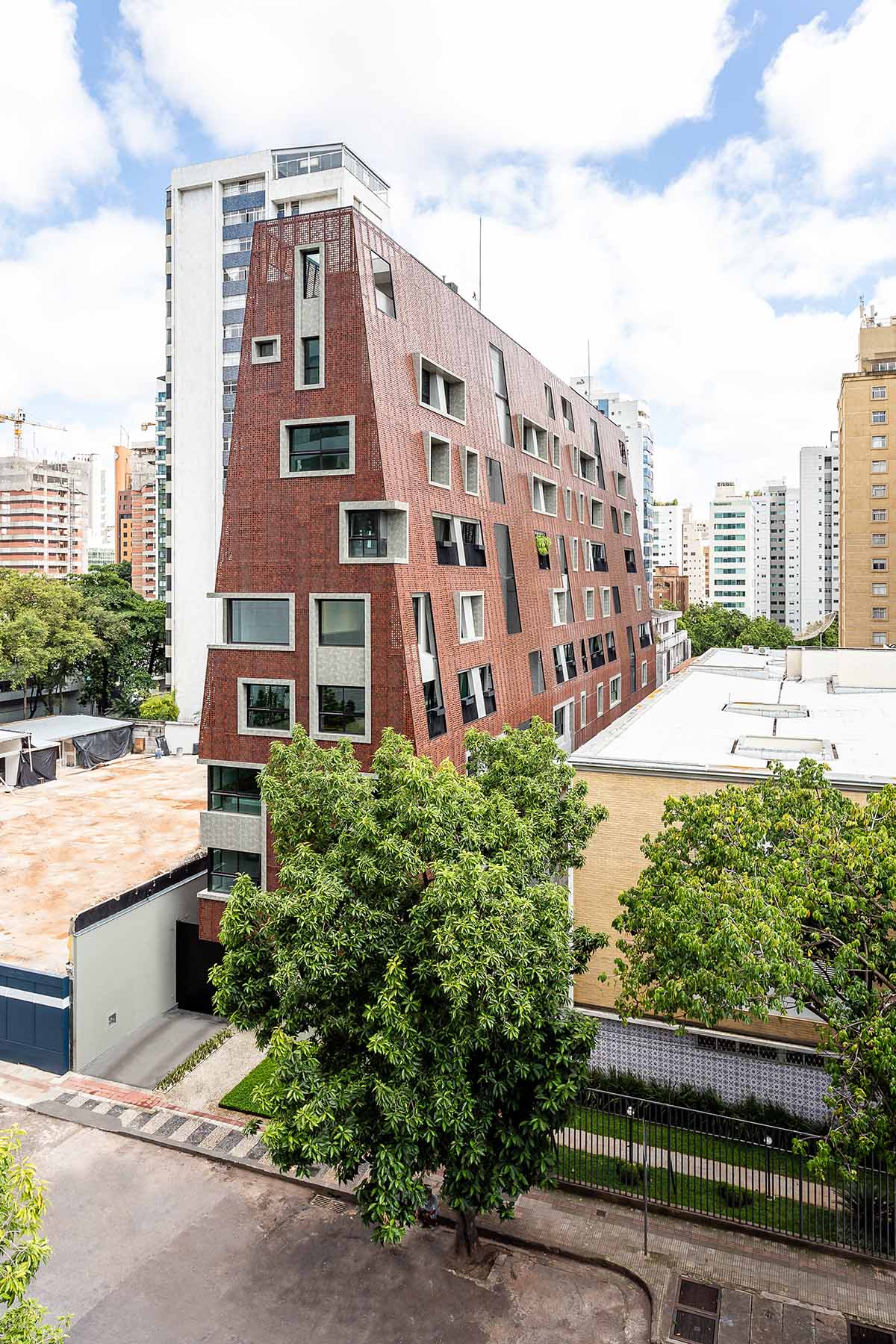Gisele Borges Arquitetura построила земляной красноватый жилой дом на узком участке в Бразилии. 