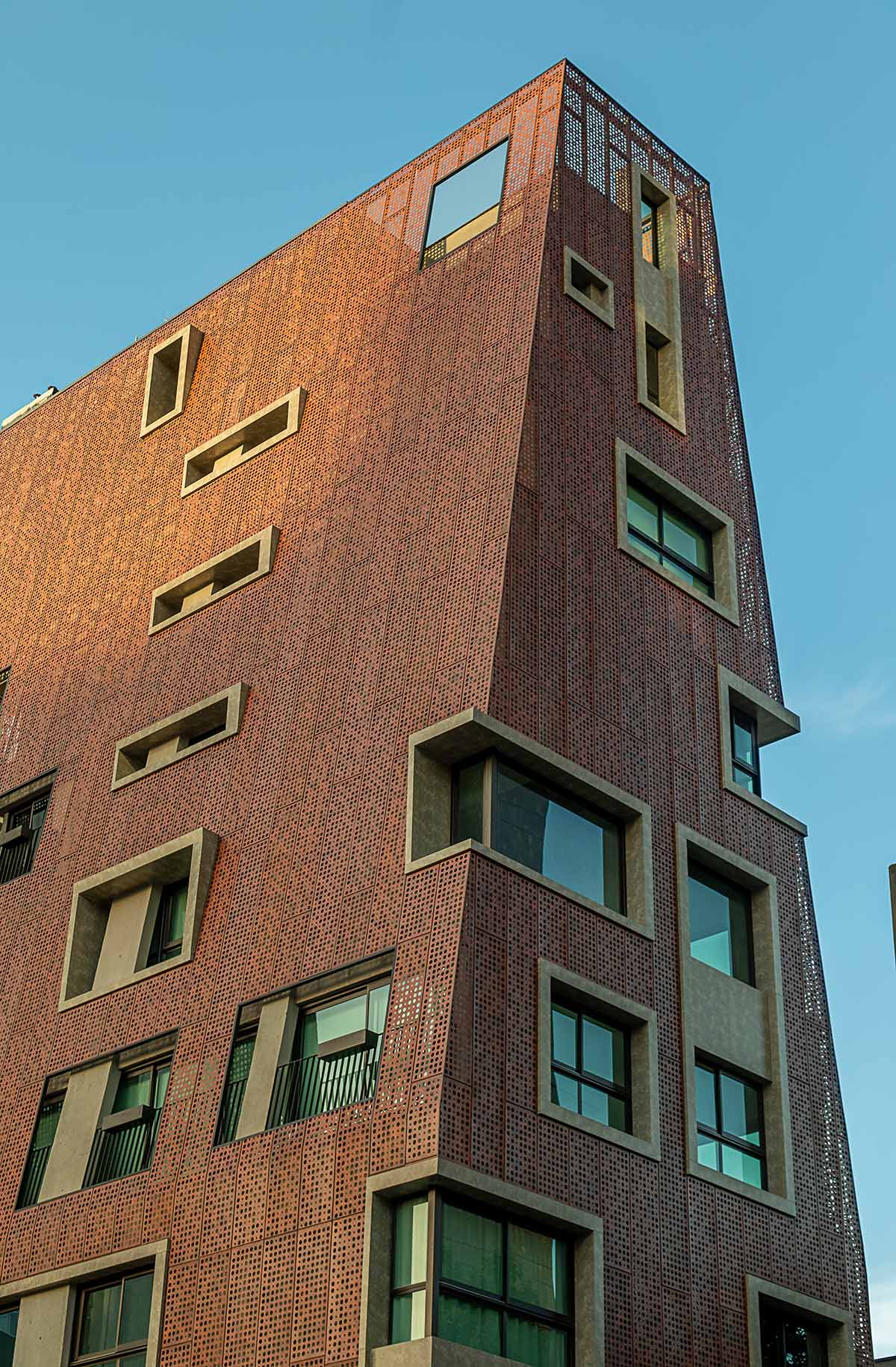 Gisele Borges Arquitetura built earthy reddish residential block on a narrow plot in Brazil