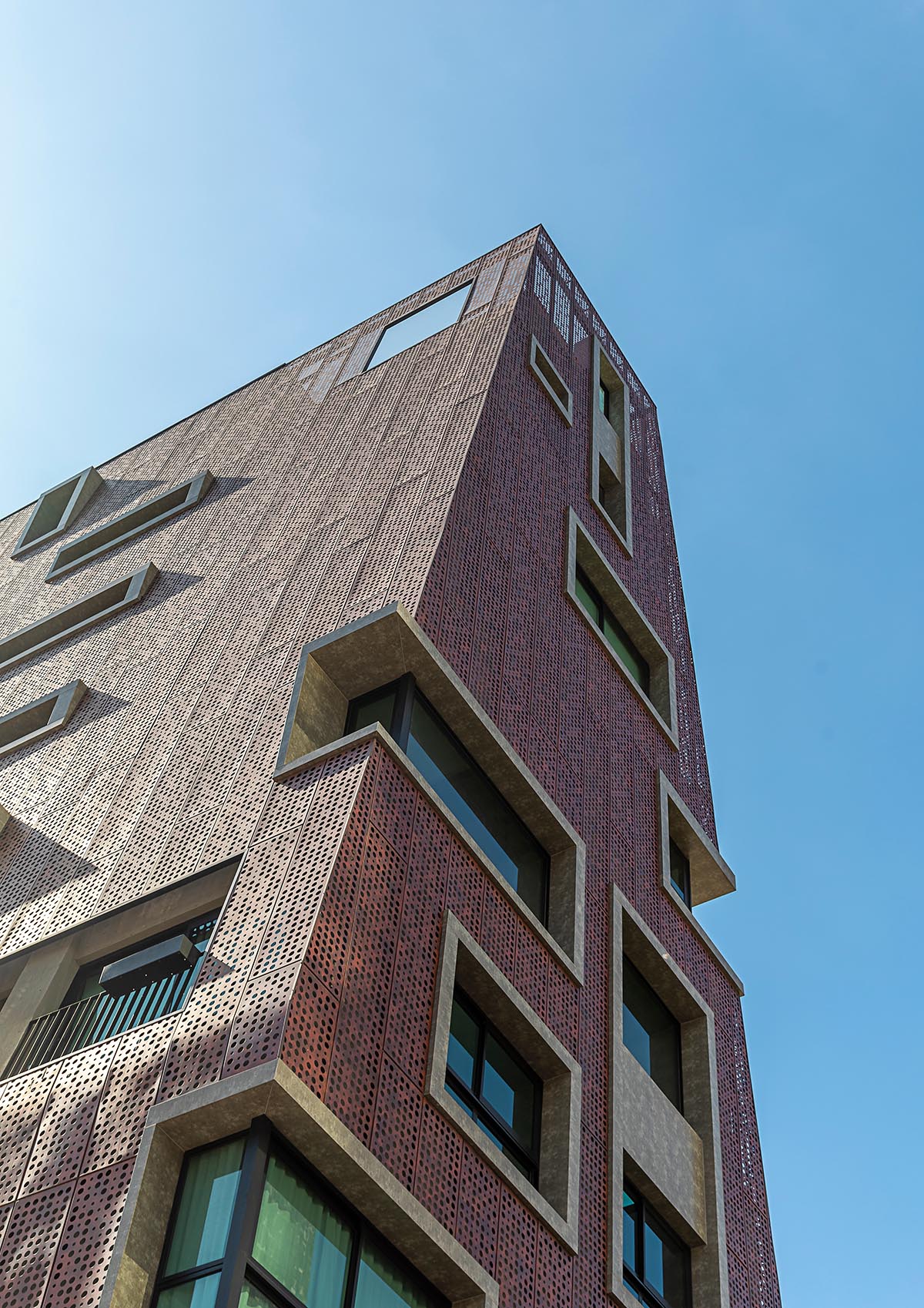 Gisele Borges Arquitetura built earthy reddish residential block on a narrow plot in Brazil