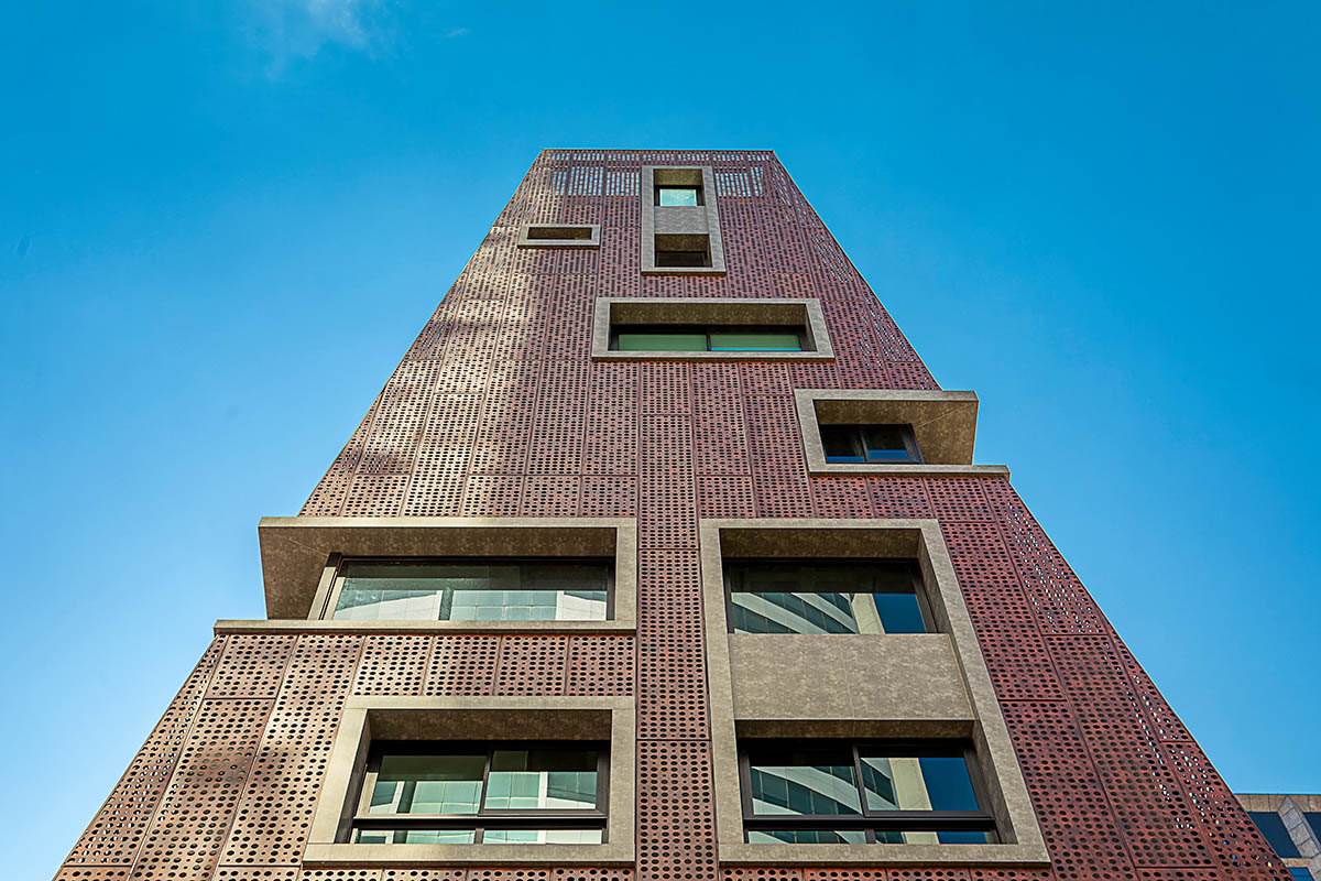 Gisele Borges Arquitetura built earthy reddish residential block on a narrow plot in Brazil