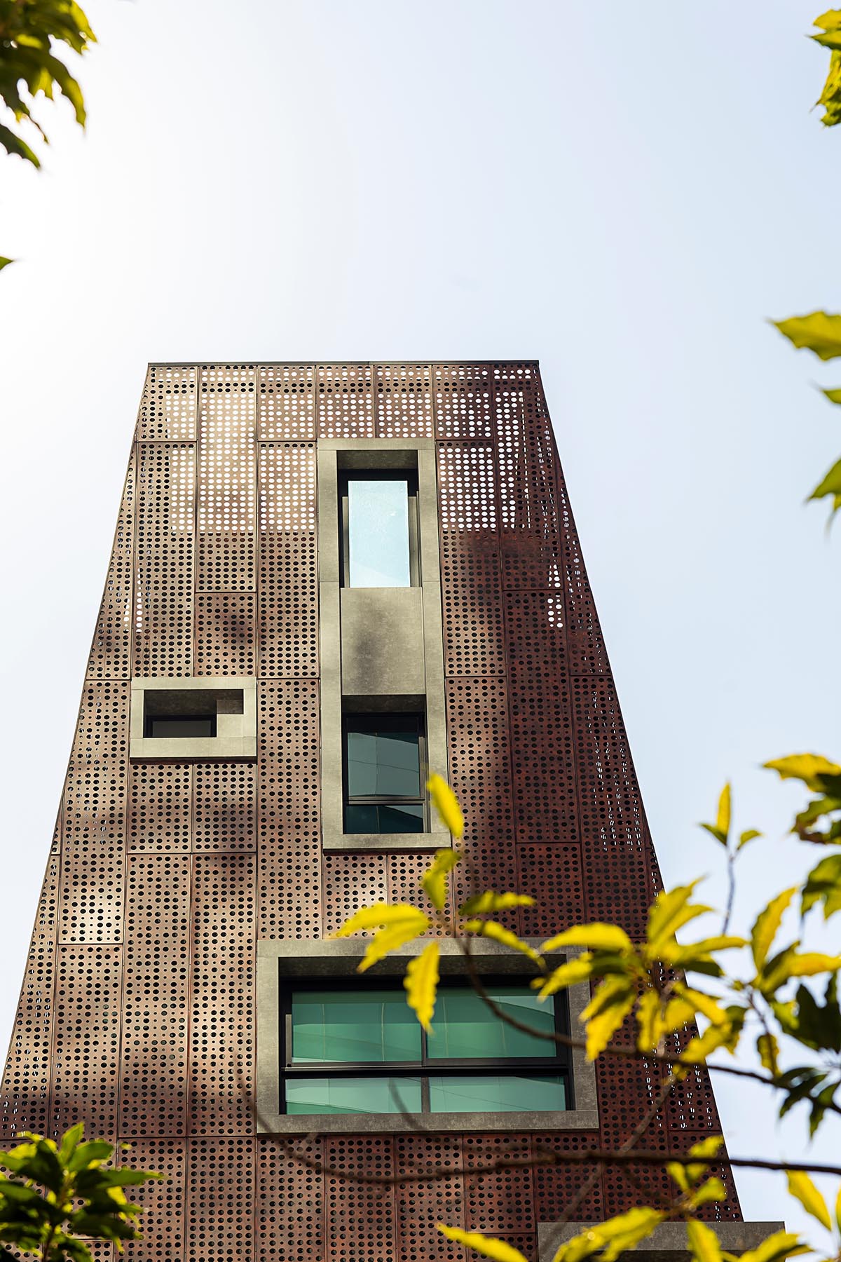 Gisele Borges Arquitetura построила земляной красноватый жилой дом на узком участке в Бразилии. 