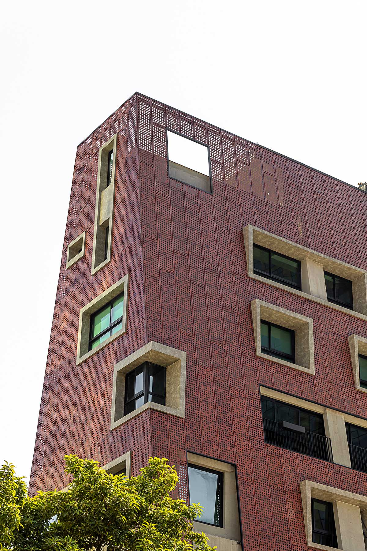 Gisele Borges Arquitetura built earthy reddish residential block on a narrow plot in Brazil