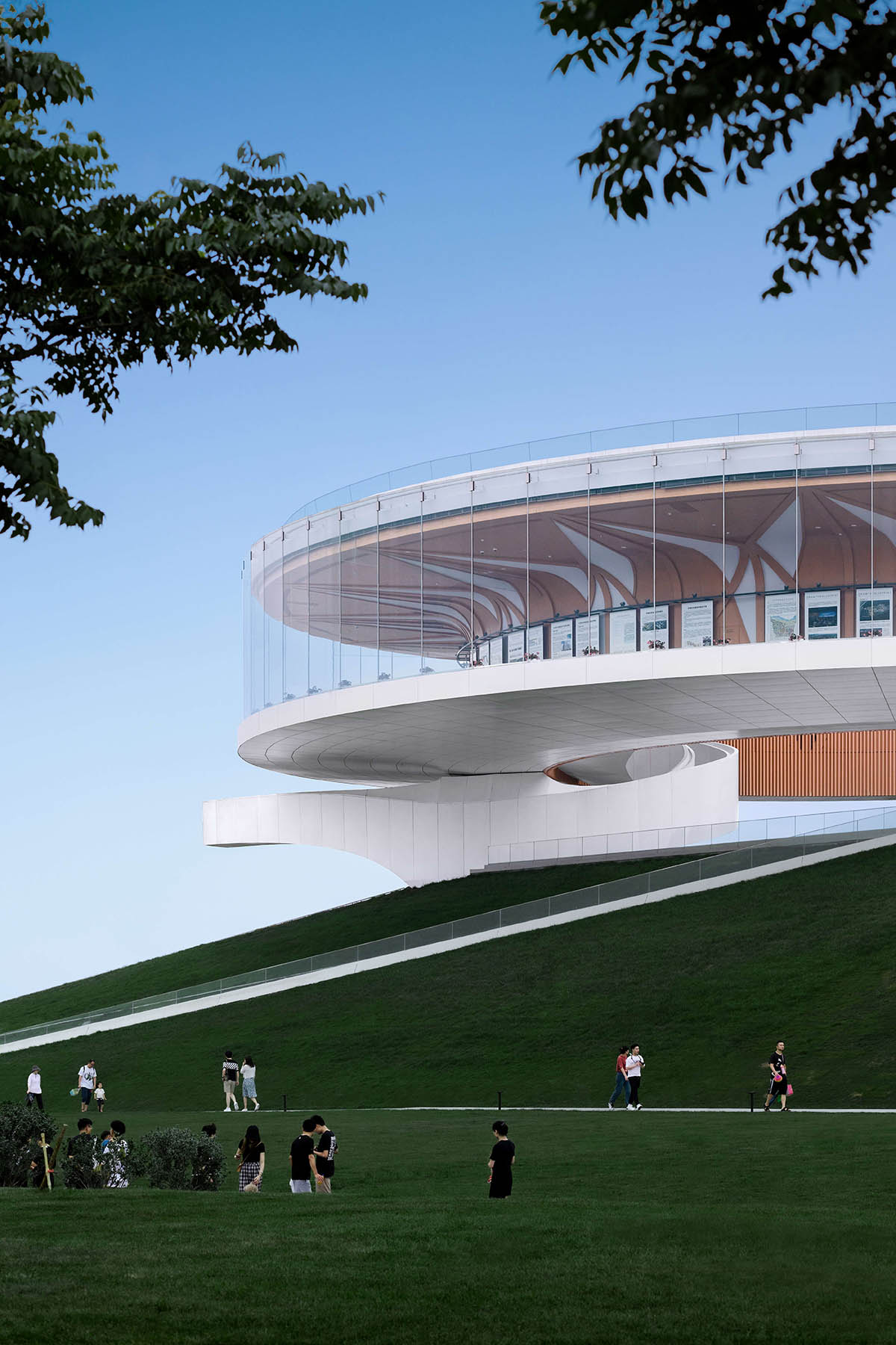 STUDIO A+ designs climbable ring-shaped art center on a green mound in Zhengzhou