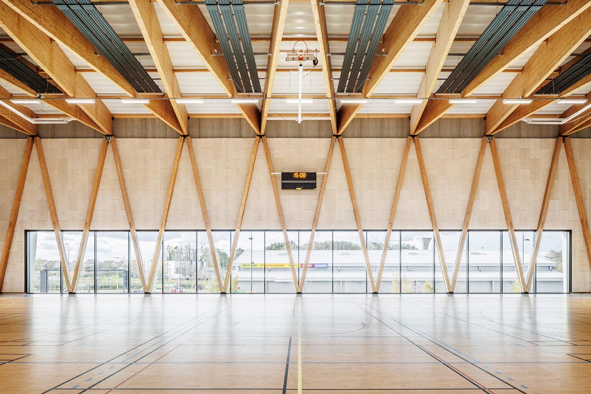The gold-colored, folded facade gives a striking and symbolic presence to a new sports complex 