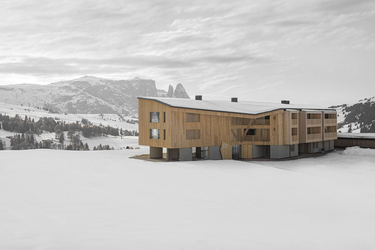 Icaro Hotel featuring wooden colonnade frames embraces alpine heritage landscape in Italy 