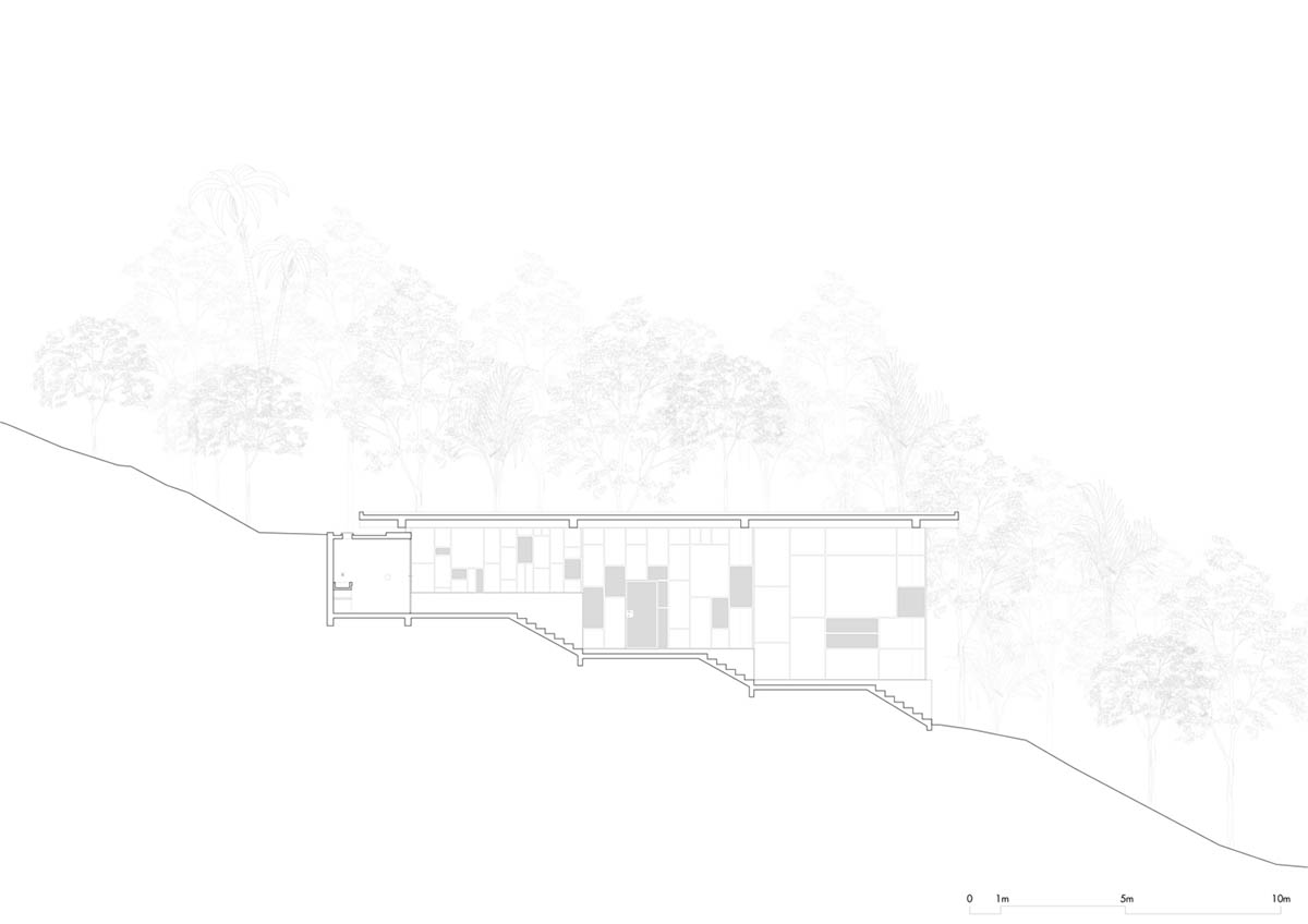 Two bold concrete platforms define this transparent library house by Atelier Branco Arquitetura