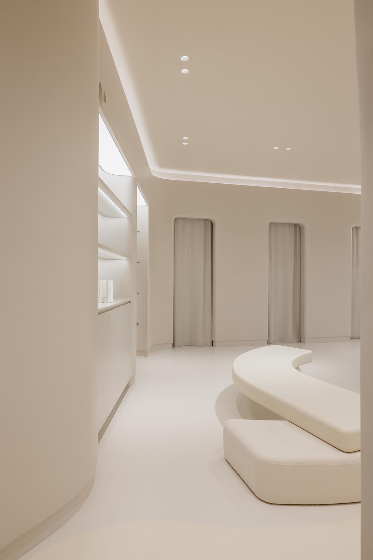 Store interiors by Sò Studio feature soft beige tones to give the feeling of