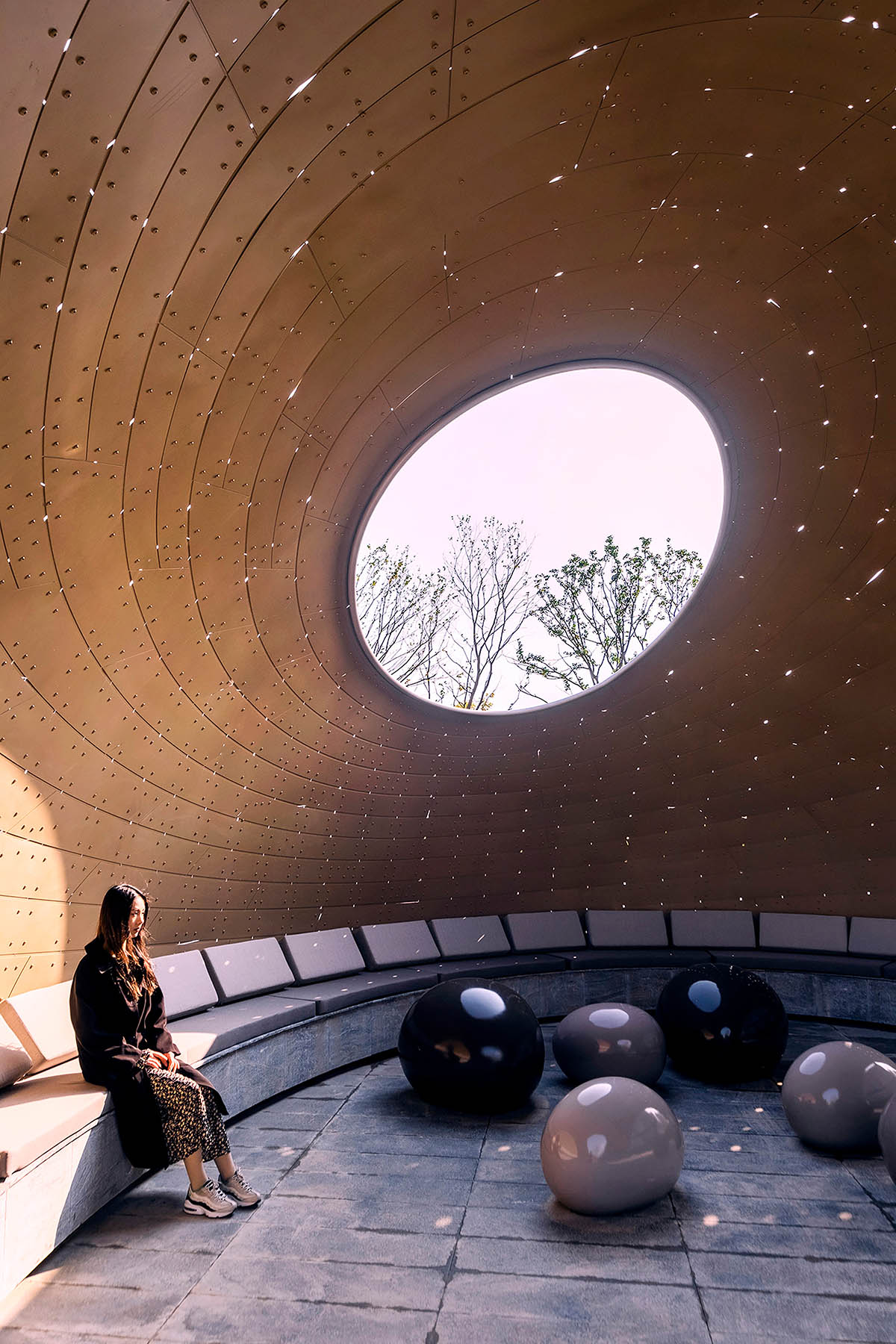   A thin-shell pavilion inspired by the bionic weaving appearance of birds' nests sits on a pool 