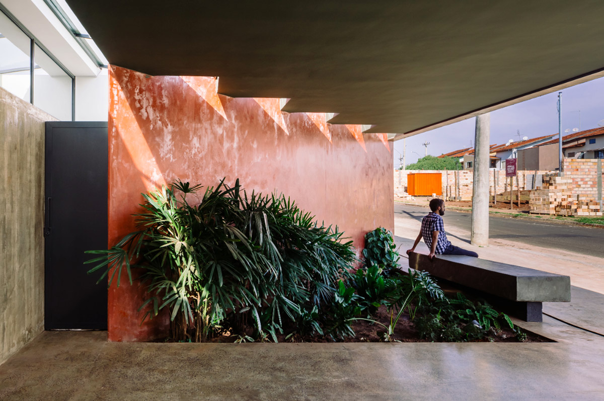 V&atilde;o designed recessed volumes and leaning red wall to offer flexible spaces for this Brazilian house