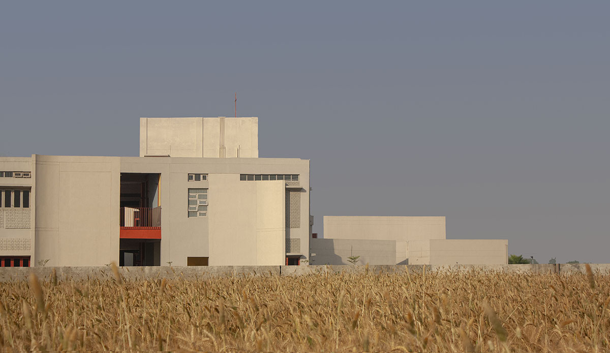 Kamat & Rozario Architecture built school with fortress-like blank walls and colored bridges