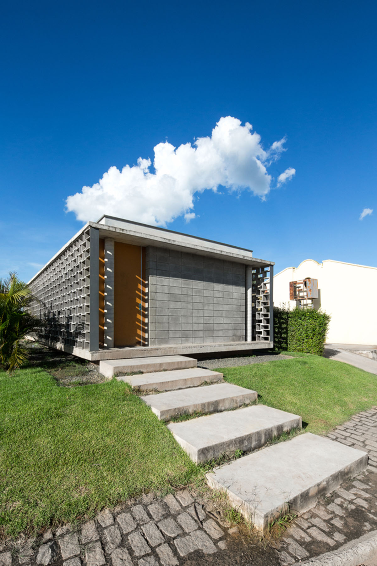 Hollowed-out concrete screens create changing filter for this service building in São Paulo
