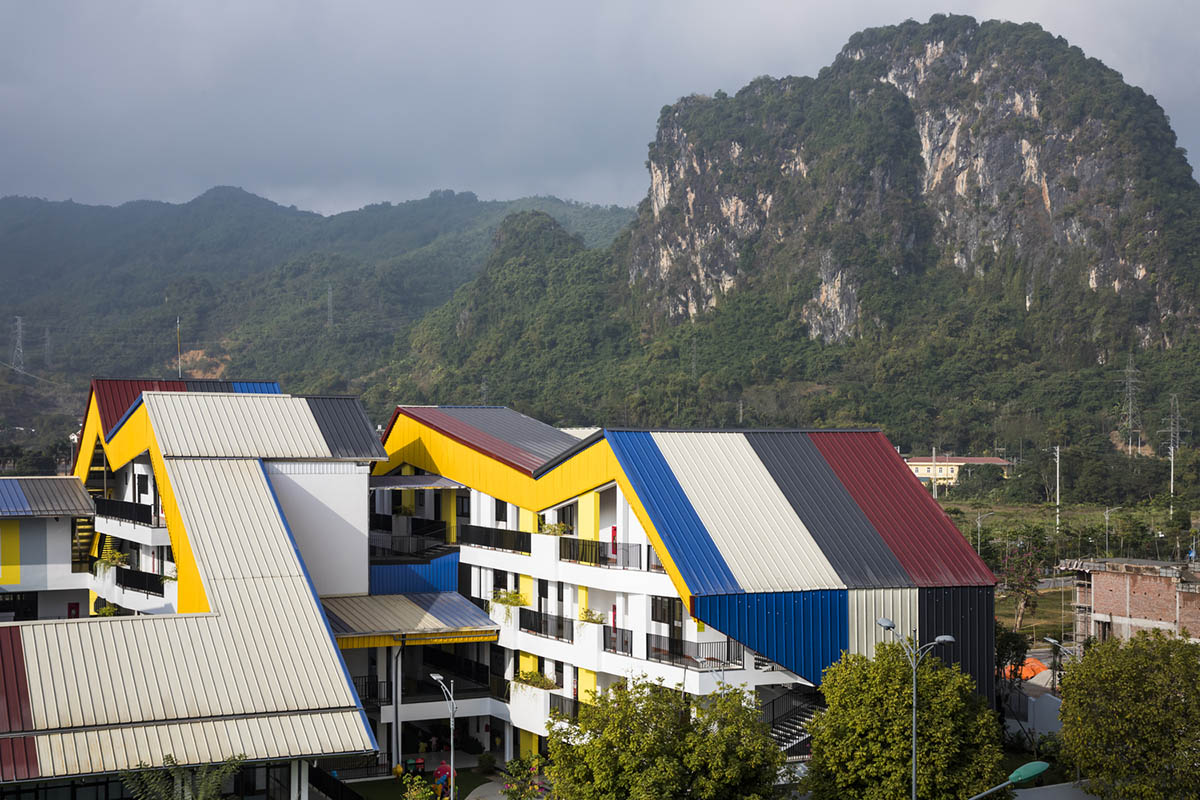 Multi-colored hipped roofs form this kindergarten and primary school in Vietnam