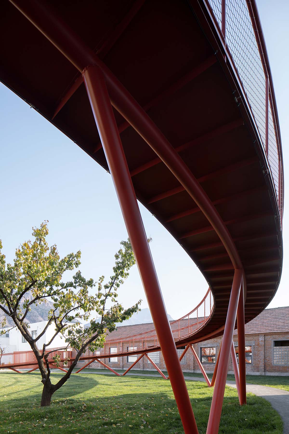 REDe Architects and Moguang Studio add red circular platform to renovated youth activity center