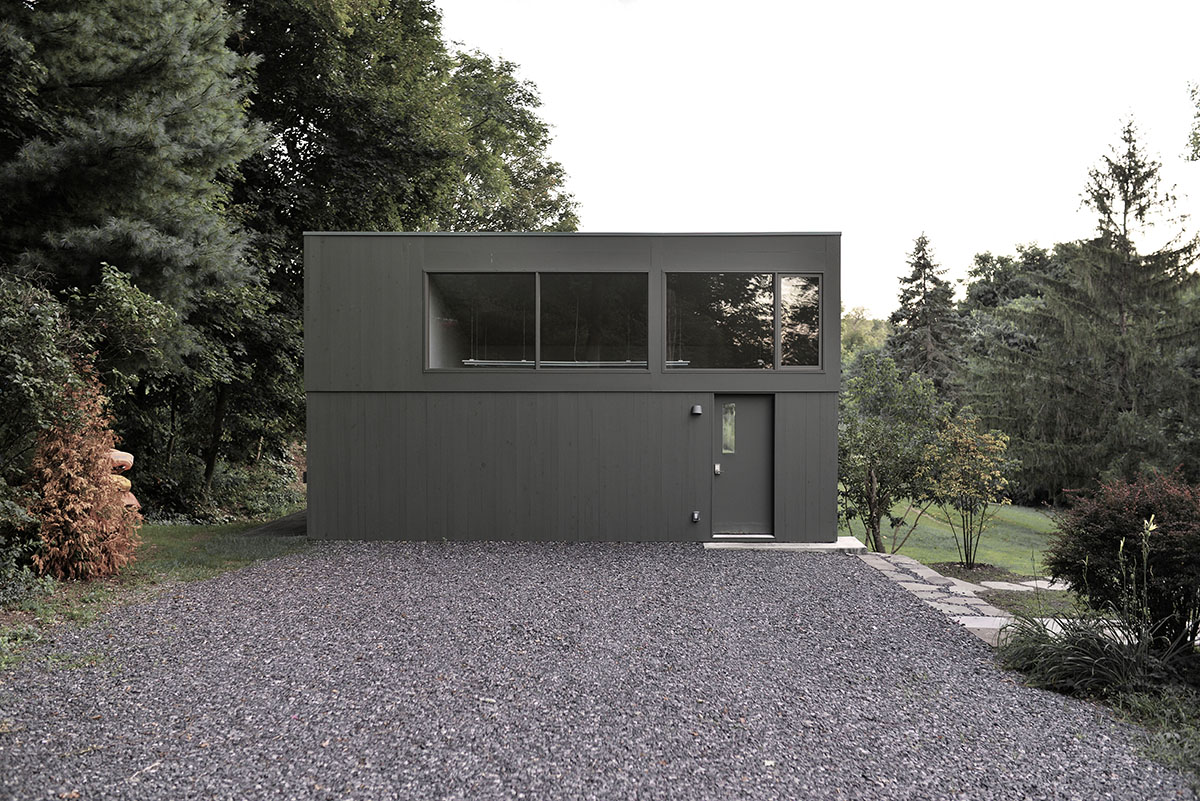 An artist's studio floats and illuminates in the landscape in Germantown