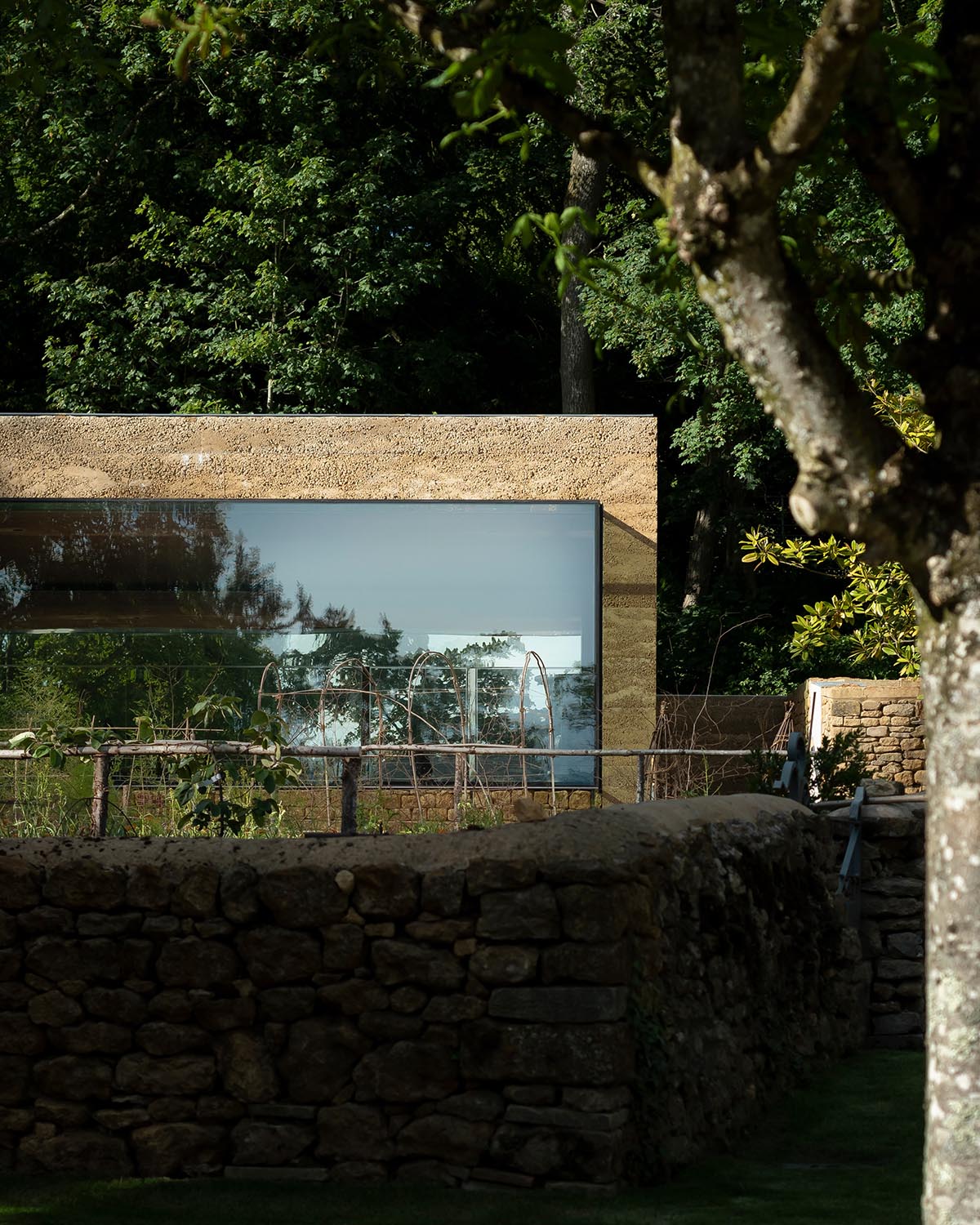 Invisible Studio creates large window for a gymnasium overlooking to a productive garden in Somerset