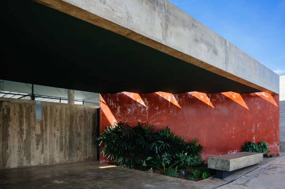 V&atilde;o designed recessed volumes and leaning red wall to offer flexible spaces for this Brazilian house