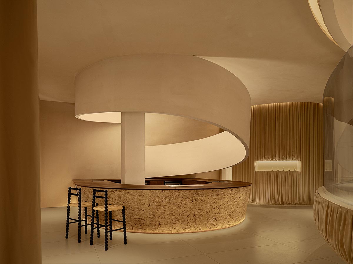 Tea house interiors wrapped by earth-toned fabric curtains act like 