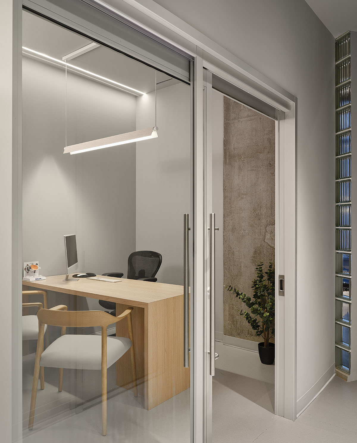 Eye care clinic features a sweeping glass block wall to disperse light in the interior