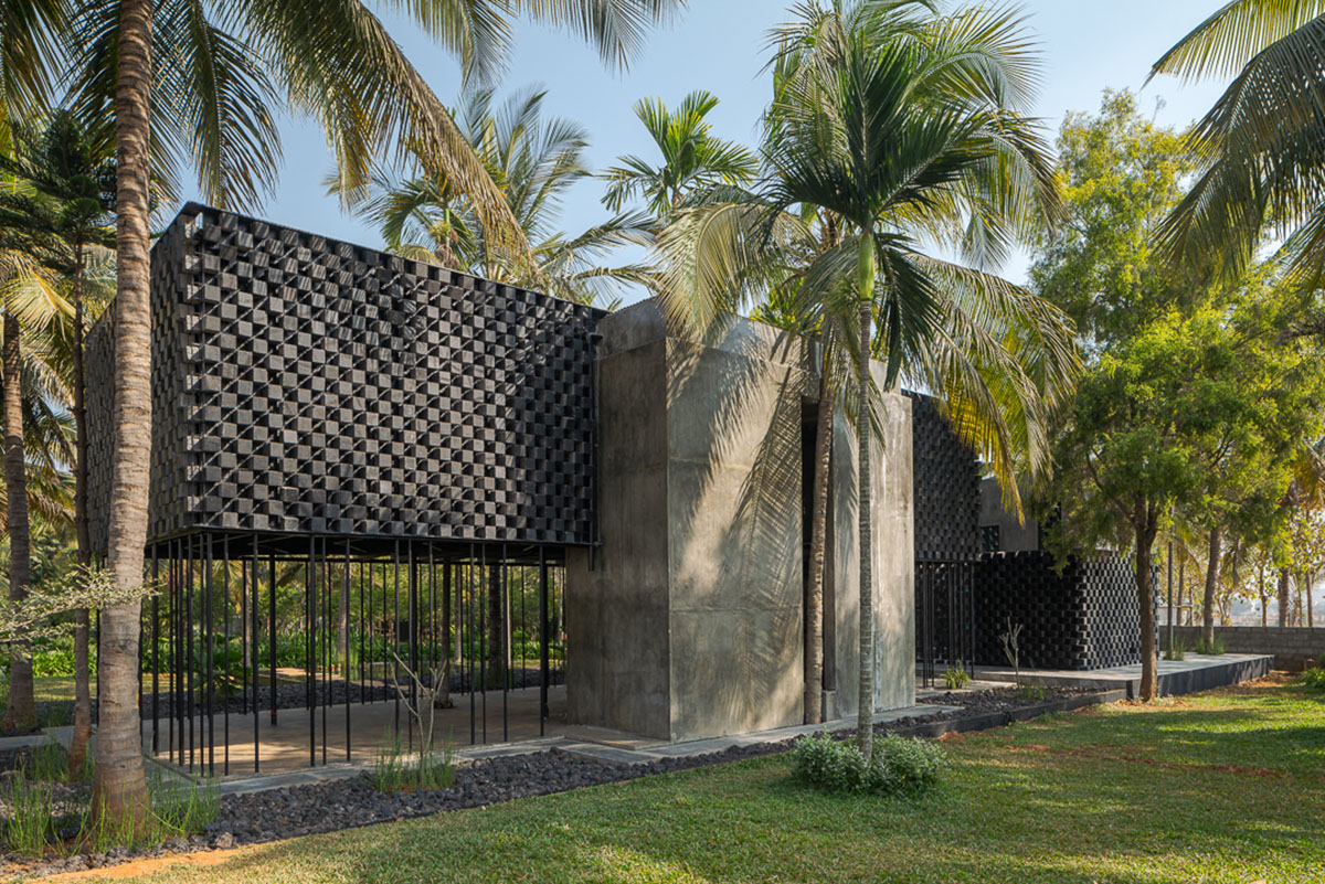 Parallax designs black weekend house raised on slender stilts within coconut trees in Bangalore