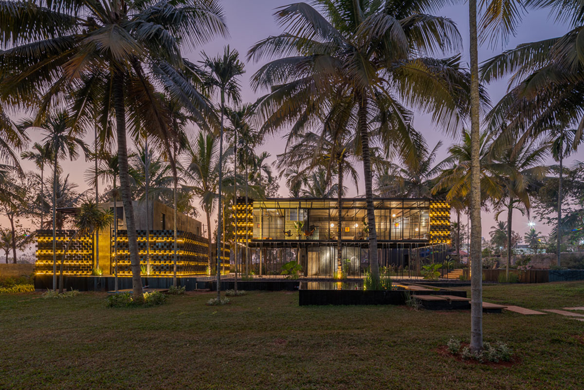 Parallax designs black weekend house raised on slender stilts within coconut trees in Bangalore