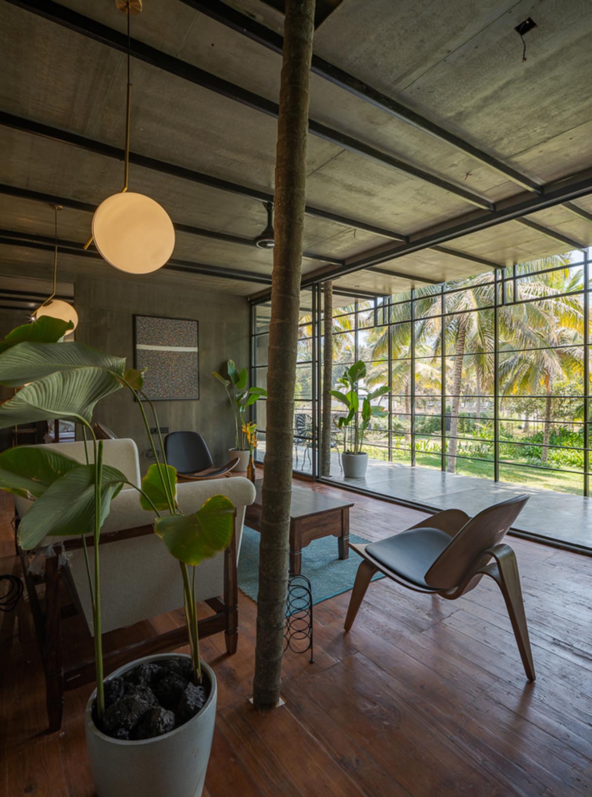 Parallax designs black weekend house raised on slender stilts within coconut trees in Bangalore