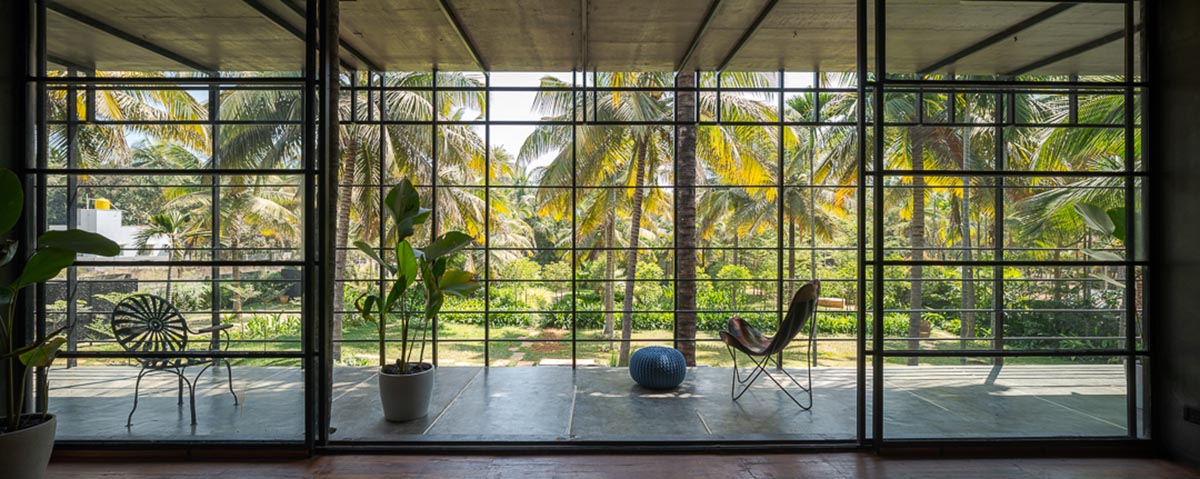 Parallax designs black weekend house raised on slender stilts within coconut trees in Bangalore