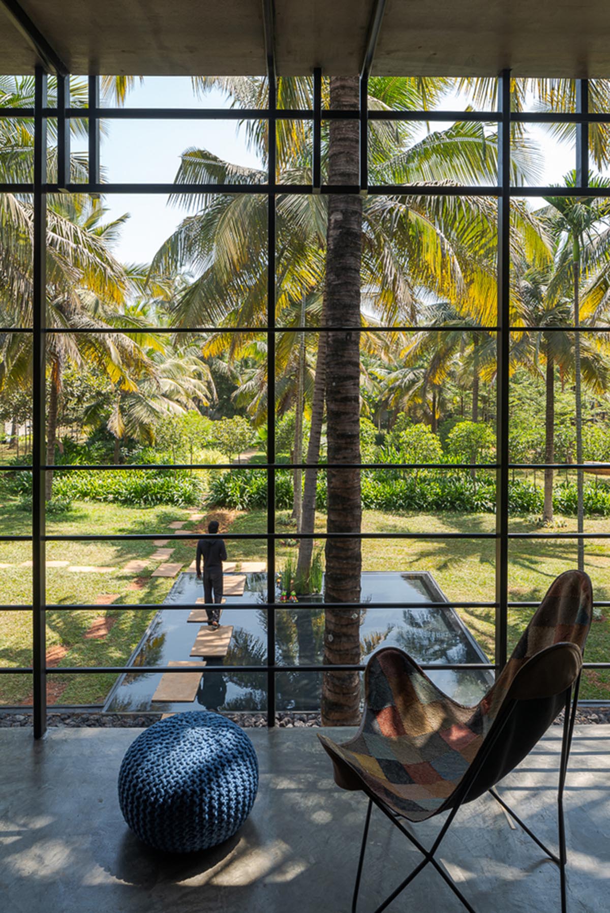 Parallax designs black weekend house raised on slender stilts within coconut trees in Bangalore