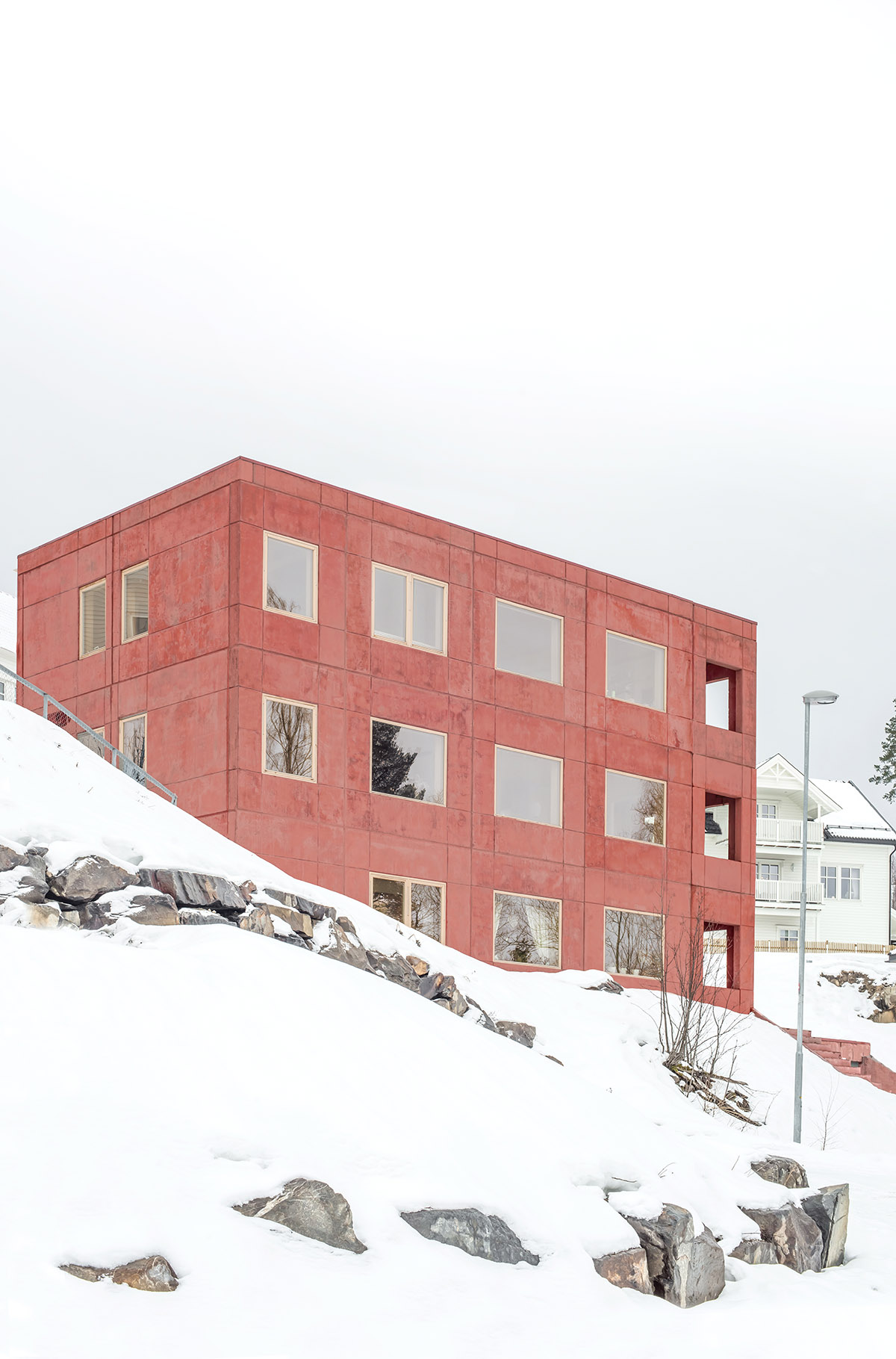 Sanden+Hodnekvam Architects built family house wrapped by red pigmented concrete panels in Norway
