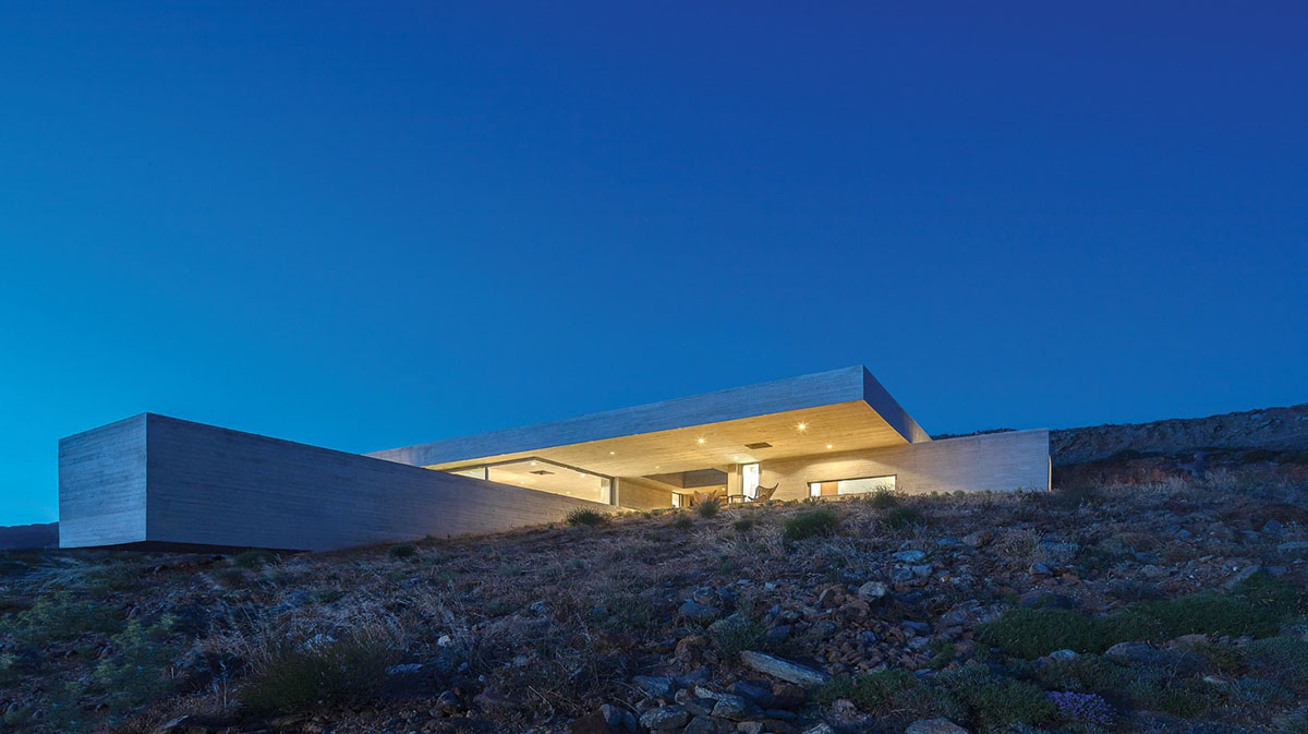 Swimming pool is bravely extended from inside of this concrete house towards endless view in Tinos