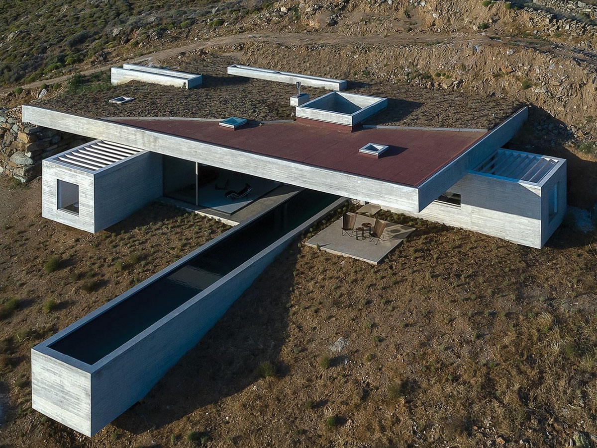 Swimming pool is bravely extended from inside of this concrete house towards endless view in Tinos