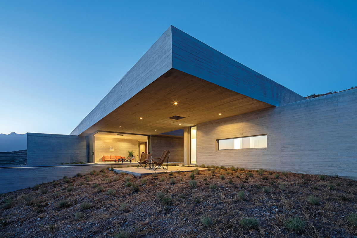 Swimming pool is bravely extended from inside of this concrete house towards endless view in Tinos
