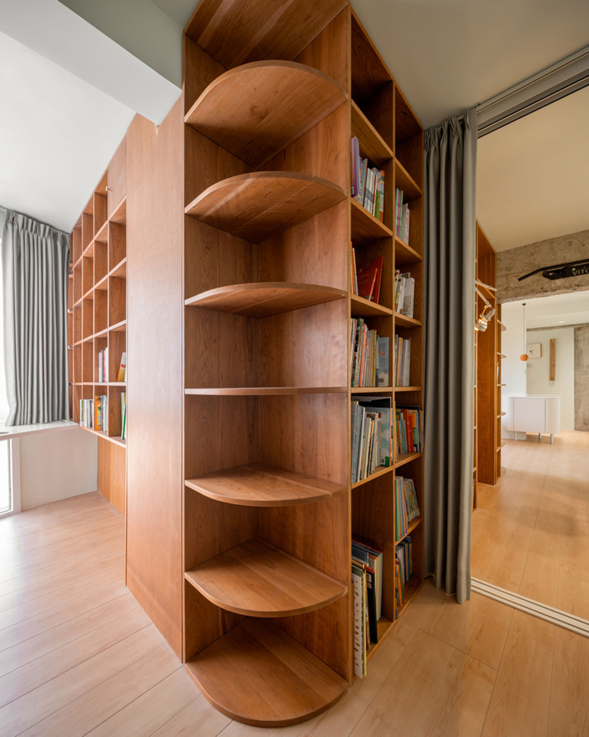 Cherry wood bookcase shapes this house by Atelier D+Y to create flexible interior in Shanghai
