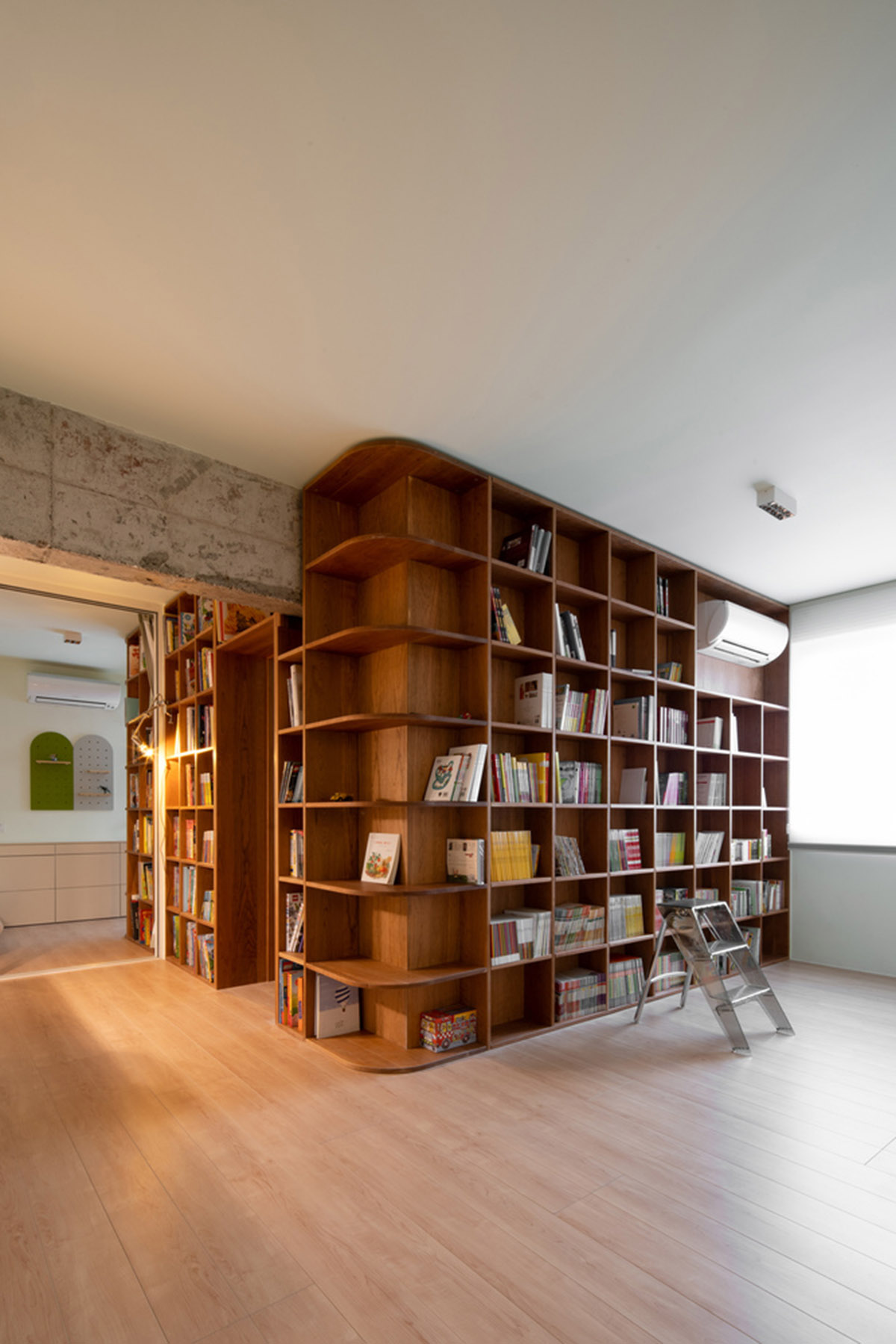 Cherry wood bookcase shapes this house by Atelier D+Y to create flexible interior in Shanghai