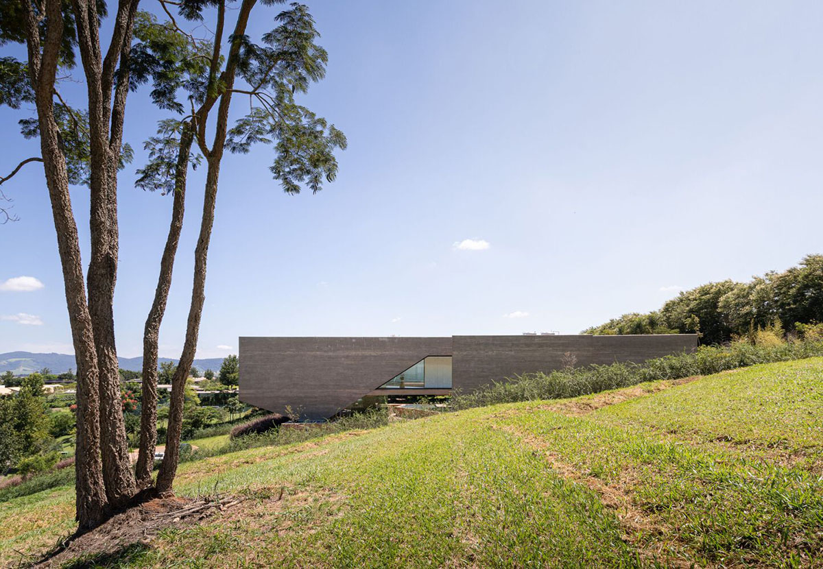 Bridge-like Brazilian house by Yuri Vital is supported by angular structural walls on sloped terrain