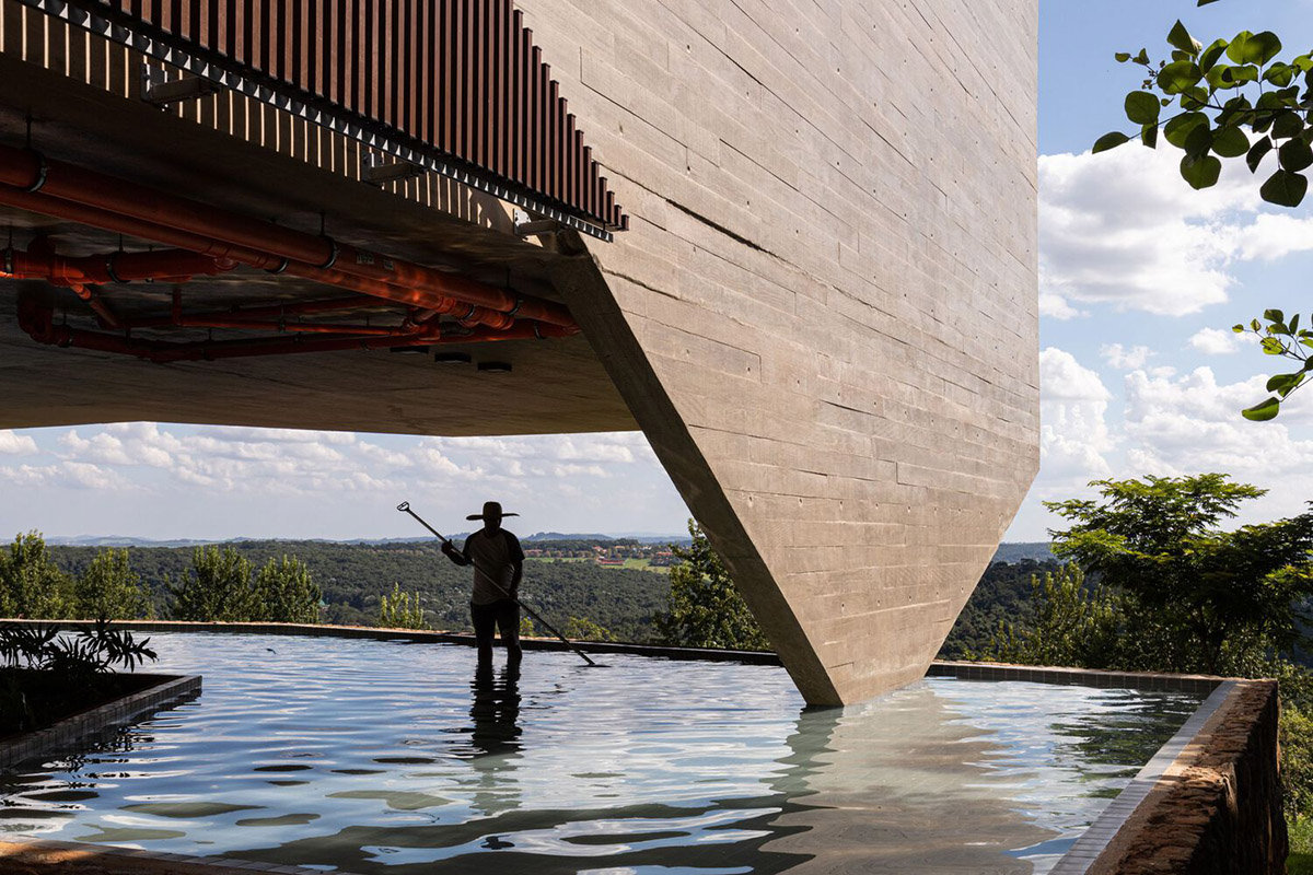 Bridge-like Brazilian house by Yuri Vital is supported by angular structural walls on sloped terrain