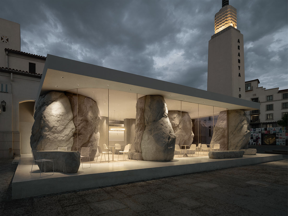 B.L.U.E. Architecture Studio adds a glazed cafe by using organic forms of stones to an open plaza