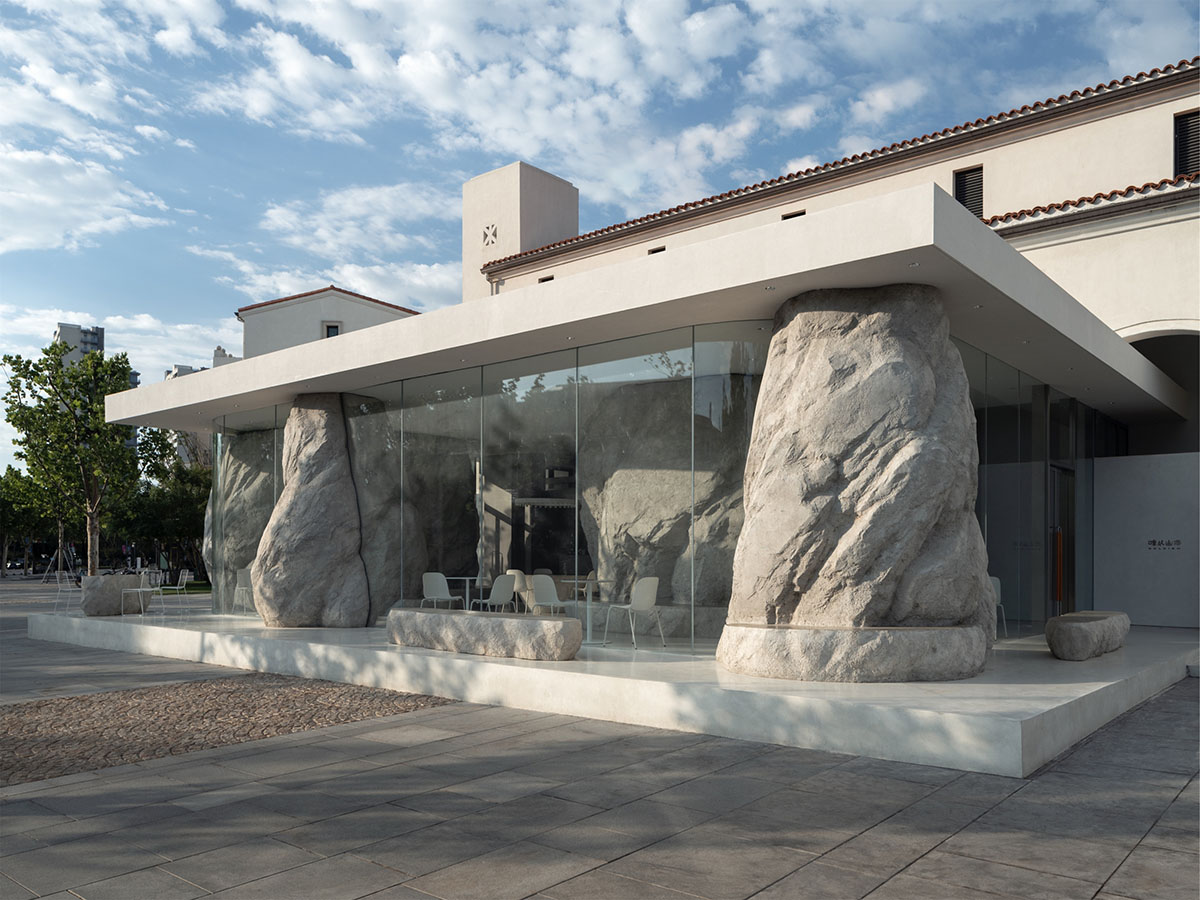B.L.U.E. Architecture Studio adds a glazed cafe by using organic forms of stones to an open plaza
