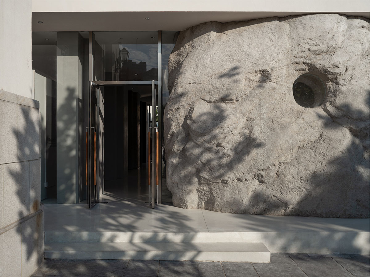 B.L.U.E. Architecture Studio adds a glazed cafe by using organic forms of stones to an open plaza