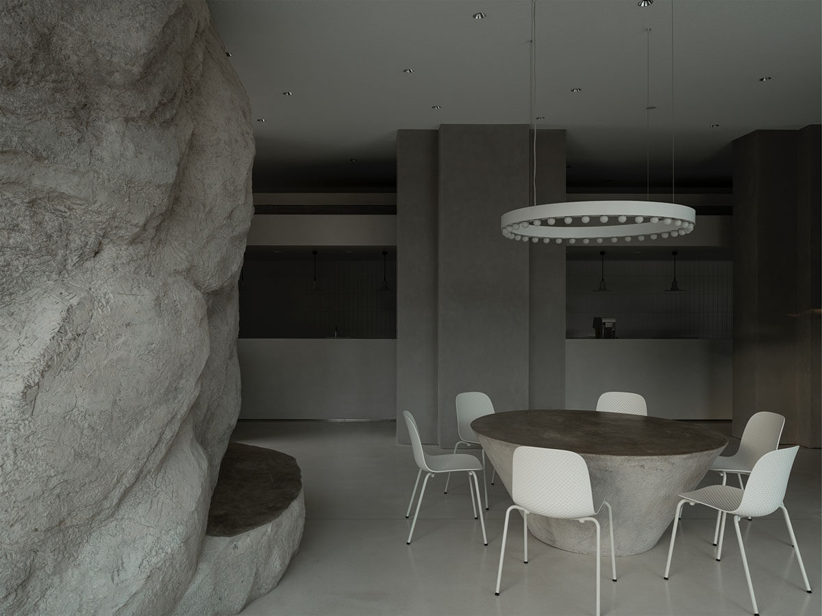 B.L.U.E. Architecture Studio adds a glazed cafe by using organic forms of stones to an open plaza