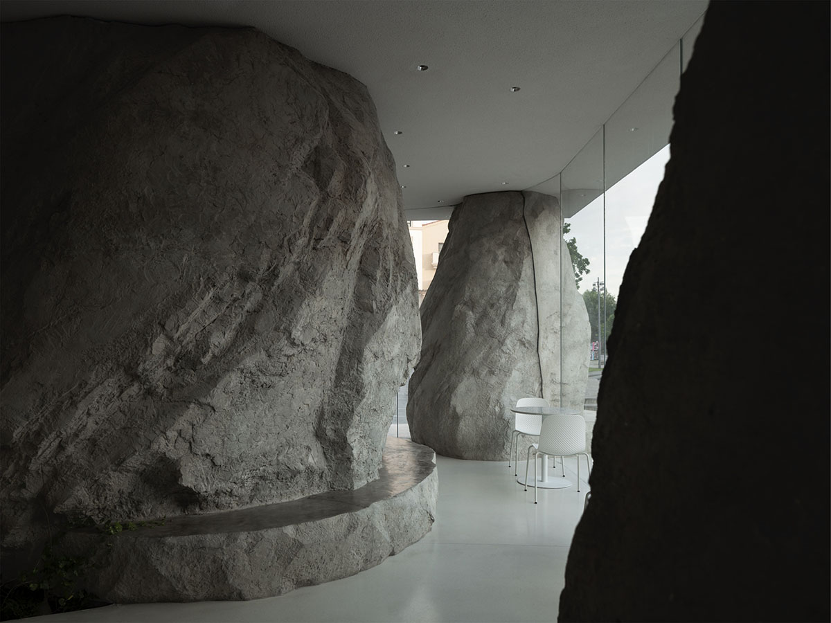 B.L.U.E. Architecture Studio adds a glazed cafe by using organic forms of stones to an open plaza