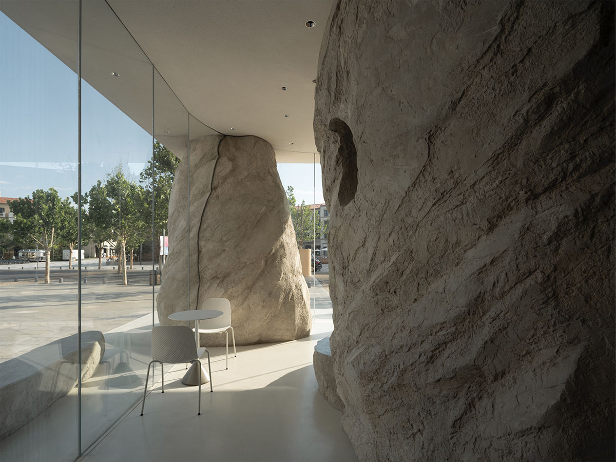 B.L.U.E. Architecture Studio adds a glazed cafe by using organic forms of stones to an open plaza