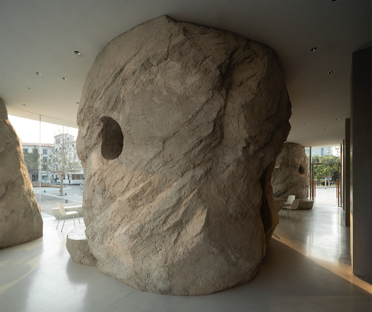 B.L.U.E. Architecture Studio adds a glazed cafe by using organic forms of stones to an open plaza