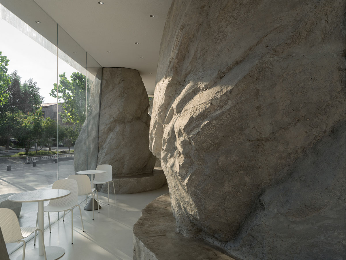 B.L.U.E. Architecture Studio adds a glazed cafe by using organic forms of stones to an open plaza