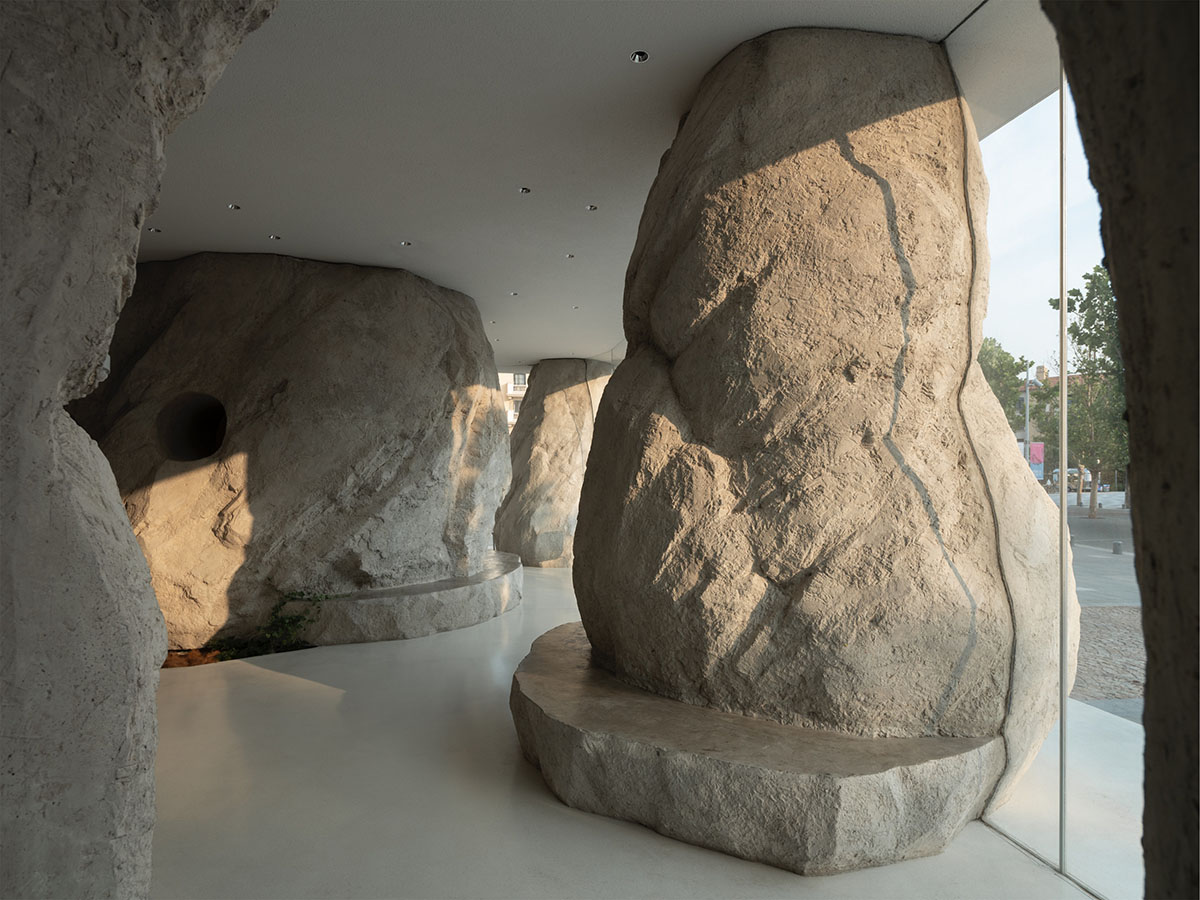 B.L.U.E. Architecture Studio adds a glazed cafe by using organic forms of stones to an open plaza