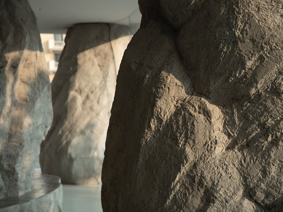B.L.U.E. Architecture Studio adds a glazed cafe by using organic forms of stones to an open plaza