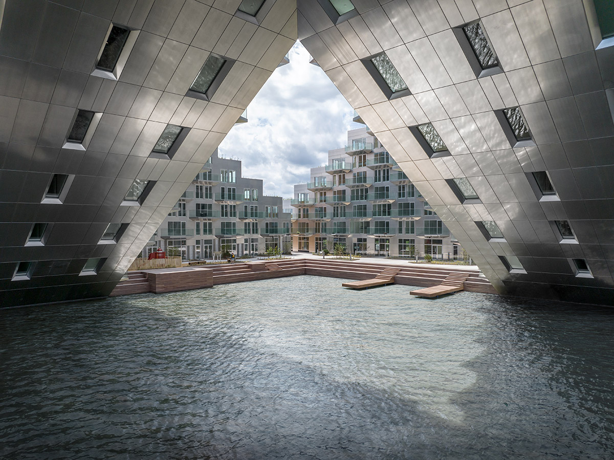 BIG and Barcode Architects built triangular housing block that its cantilevered corner forms gateway